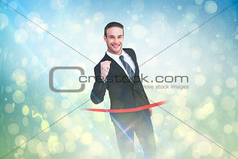 Composite image of happy businessman crossing the finish line