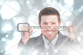 Composite image of businessman smiling and cheering