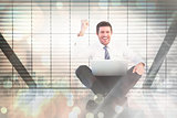 Composite image of businessman using laptop and cheering