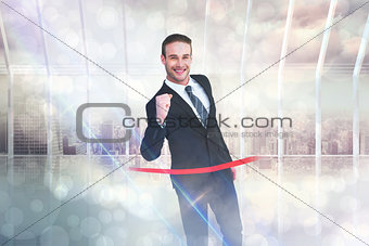 Composite image of happy businessman crossing the finish line