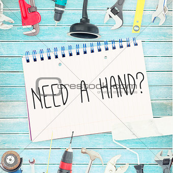 Need a hand? against tools and notepad on wooden background