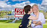 Affectionate Senior Chinese Couple In Front of House and Sign