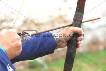 Businessman holding bow and shooting to archery target