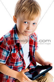 boy in a plaid shirt with a tablet computer
