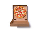 Fresh tasty Italian pizza with ham and tomatoes in box 