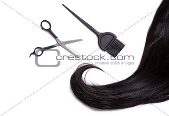 Black shiny hair with professional scissors and hair dye brush  
