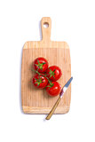 Top view of fresh tomatoes and a knife on chopping board 