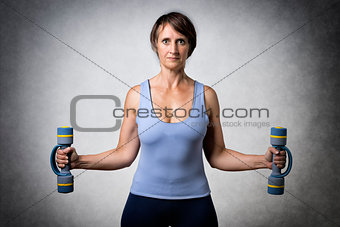 Middle aged woman with dumbbells