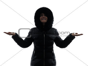 woman winter coat arms outstretched happy silhouette