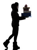 woman winter coat walking carrying christmas gifts silhouette