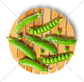 Pods of peas on bamboo board top view