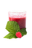 the raspberry juice in a glass with green leaves