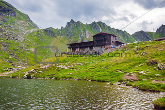 Idyllic view with typical lodge on Balea Lake shore in Fagaras M