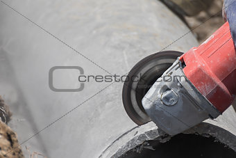 Plumbers cutting concrete water pipes