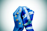hands patterned with the European and the Greek flag put togethe