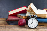 pile of books with clock