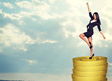 Smiling businesswoman standing on coins stack 