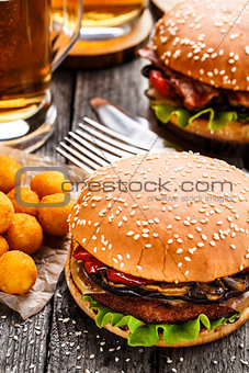 Delicious burger with fried potato balls and beer