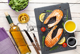 Grilled salmon and white wine on wooden table