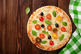 Italian pizza with cheese, tomatoes, olives and basil
