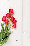 Red tulips bouquet over wood