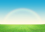 Green grass field and deep blue sky with rainbow