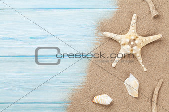 Sea sand with starfish and shells on wood