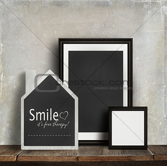 Chalkboard with quote and frames on table