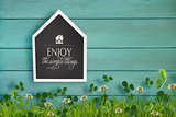 House shaped chalkboard and grass on wood