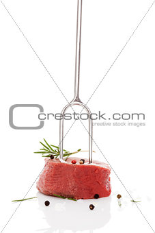 Raw steak on fork.