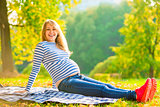 Young expectant mother comfortable resting in the park