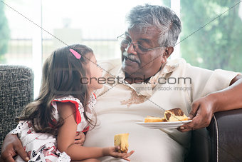 Granddaughter and grandfather eating cake
