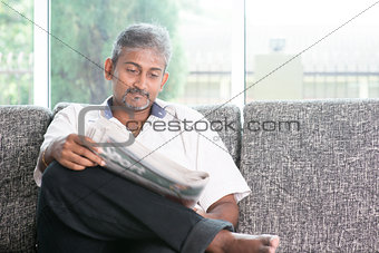 Indian man reading newspaper