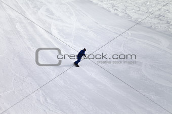 Ski slope and snowboarder at sun day