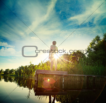 Young Man Standing on the Pier by Lake