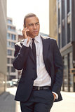 Young Businessman Talking on Phone In the Street