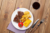 Steak with grilled potato, corn, salad and red wine