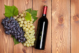 Red wine bottle and bunch of grapes