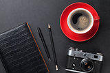 Desk with camera, supplies and coffee cup