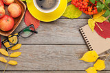 Autumn leaves, apple fruits, coffee cup and notepad
