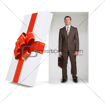Businessman with suitcase in gift box on white
