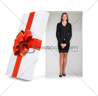 Businesswoman looking at camera in gift box