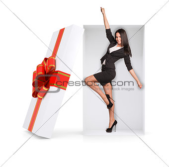 Businesswoman in winner posture inside gift box