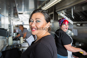 Three Busy Workers inside  a Food Truck 