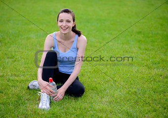 Beautiful Smiling Woman Relaxing on the Grass in the Park