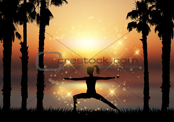 Silhouette of female in yoga pose in tropical landscape