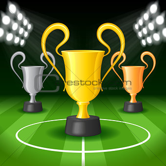 Soccer Background with Bright Spot Lights and Three Award Trophy