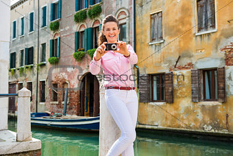 Smiling woman pointing camera and taking photo