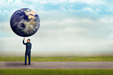 businessman holding planet earth with one finger 