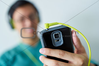 Chinese Man With Green Headphones Listens Music Podcast Phone